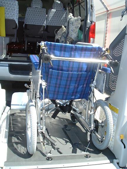 車椅子を固定する様子の写真。